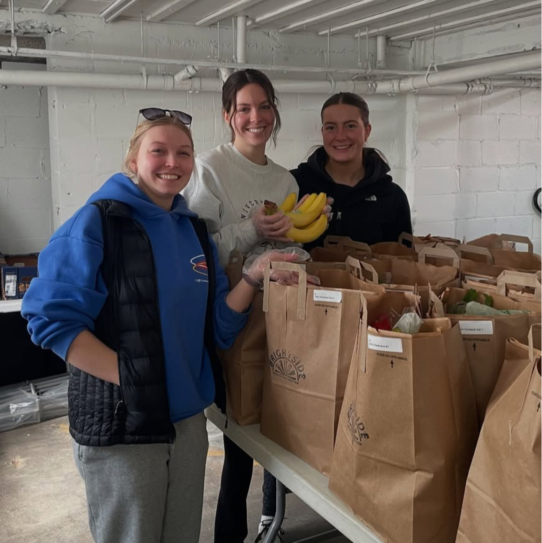 Smiling volunteer packing a BrightSide Produce delivery box at the St. Paul hub.